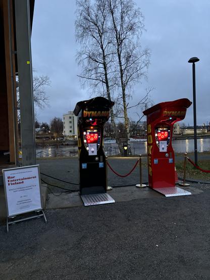 Kaksi PowerPunch-nyrkkeilypeli&auml; ulkotapahtumassa veden &auml;&auml;rell&auml; h&auml;m&auml;r&auml;ss&auml; illassa. Punainen k&ouml;ysiaita rajaa pelialueen, ja Bar Entertainment Finlandin kyltti n&auml;kyy vasemmalla.